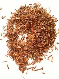 Pile of dried rooibos tea leaves and stems highlighting health benefits of naturally caffeine-free rooibos tea.