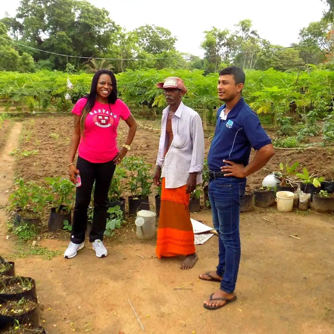 Three people standing together at what appears to be a plant nursery or garden area.